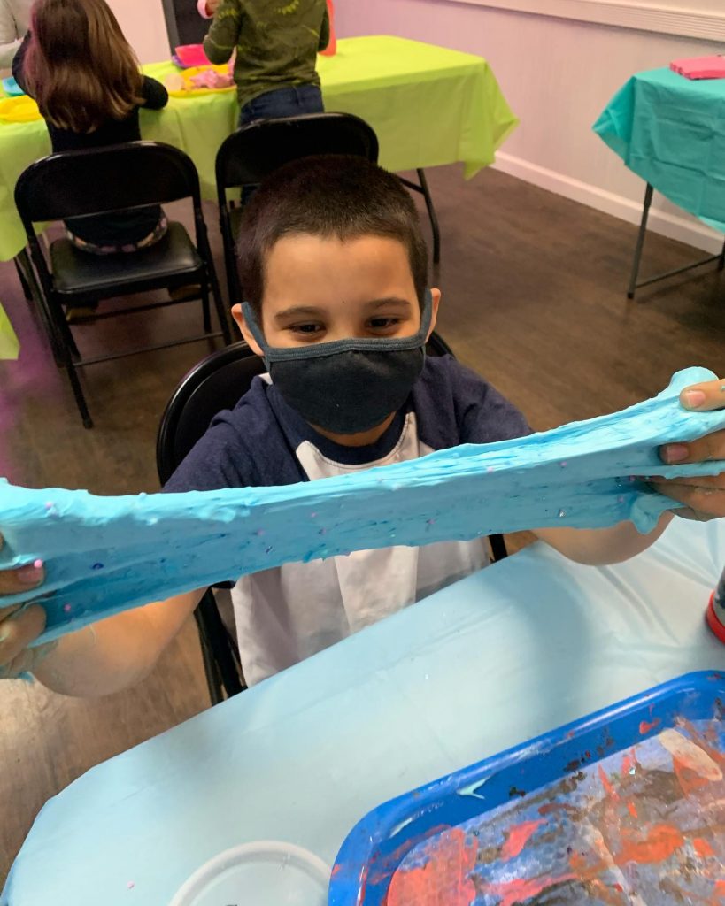 Happy boy in mask making slime