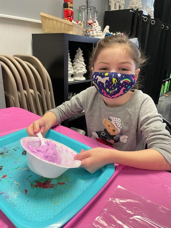 Happy girl in mask making slime