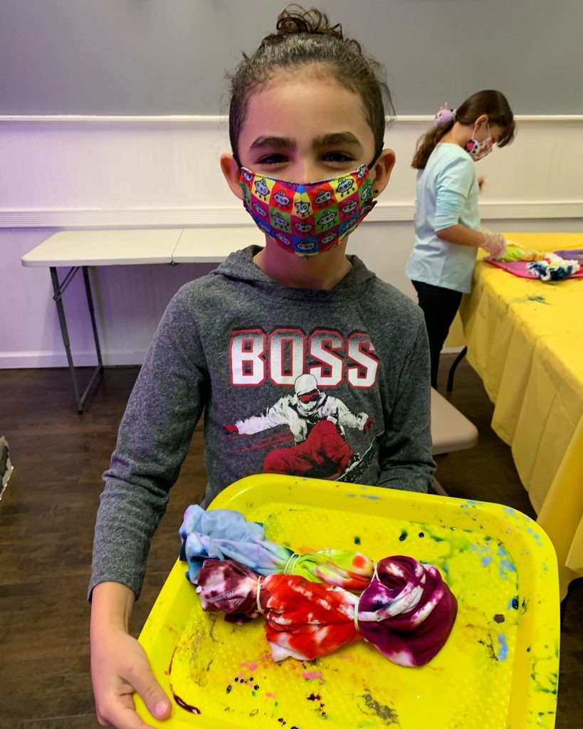 Child in mask with tie dye shirt