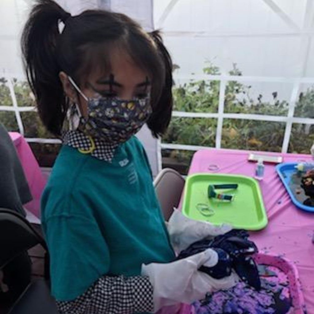 Girl in outdoor party tent making tie dye