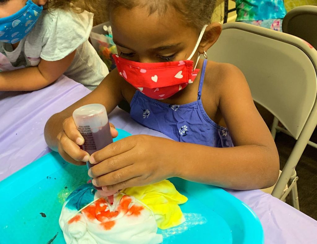 Cute girl in mask making tie dye