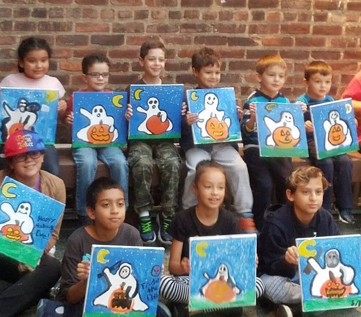 Children showing Halloween canvas paintings