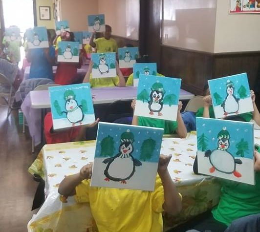 School kids showing penguin themed canvas paintings